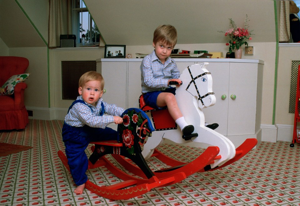 Princes William and Harry playing on rocking horses in their playroom.