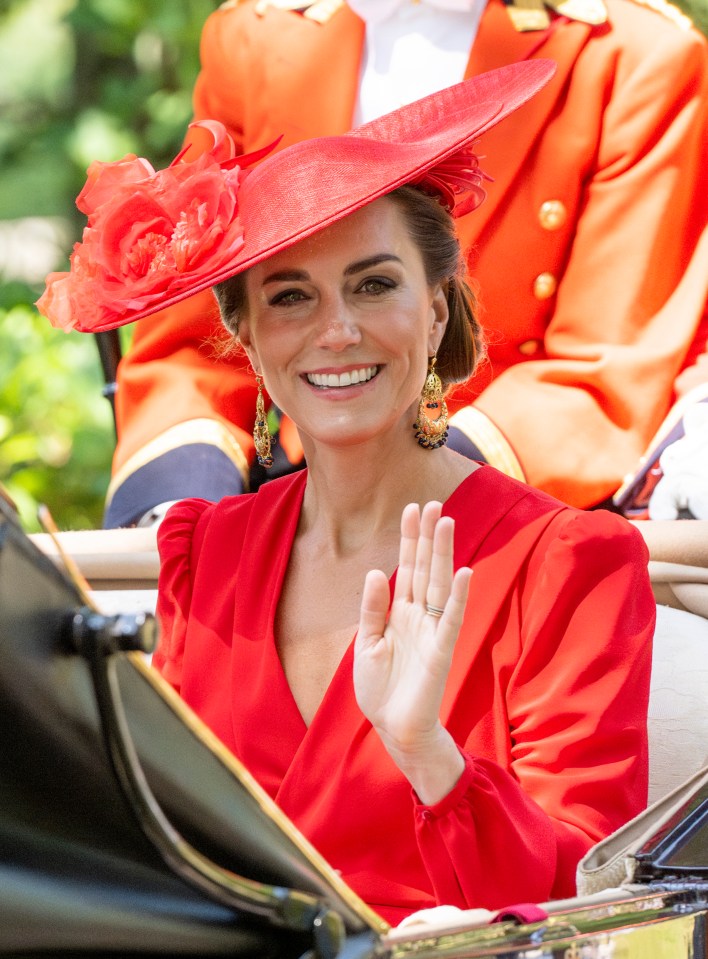 The Princess of Wales in a red dress and hat, waving.