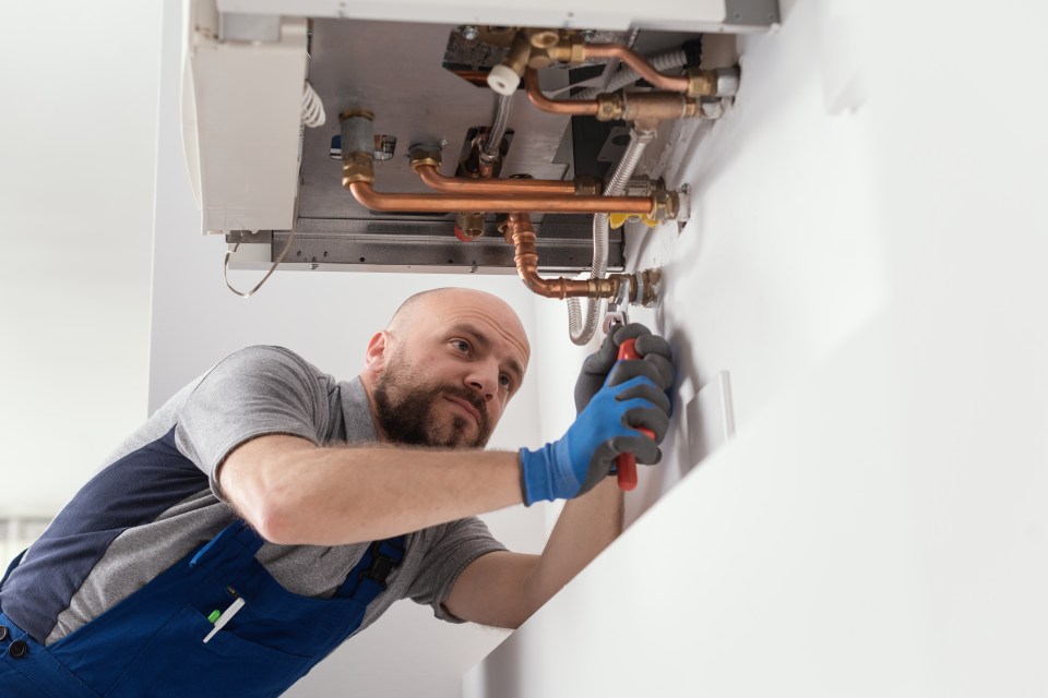 A heating engineer installing a natural gas boiler.