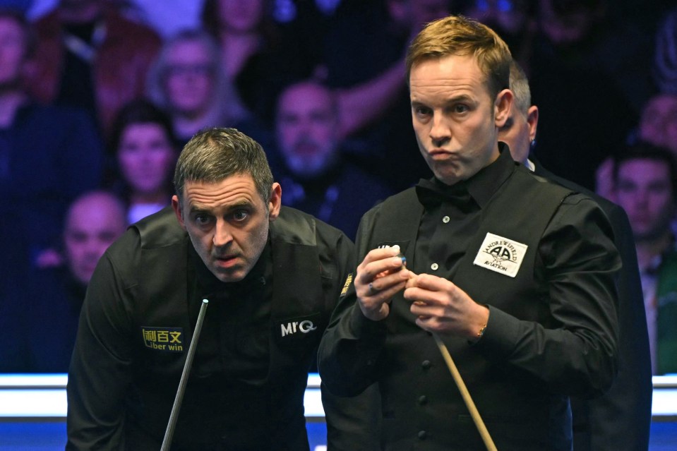 Ronnie O'Sullivan and Ali Carter playing in the Masters snooker tournament final.