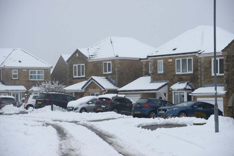 Snow-covered houses and cars in Holmfirth, Yorkshire.