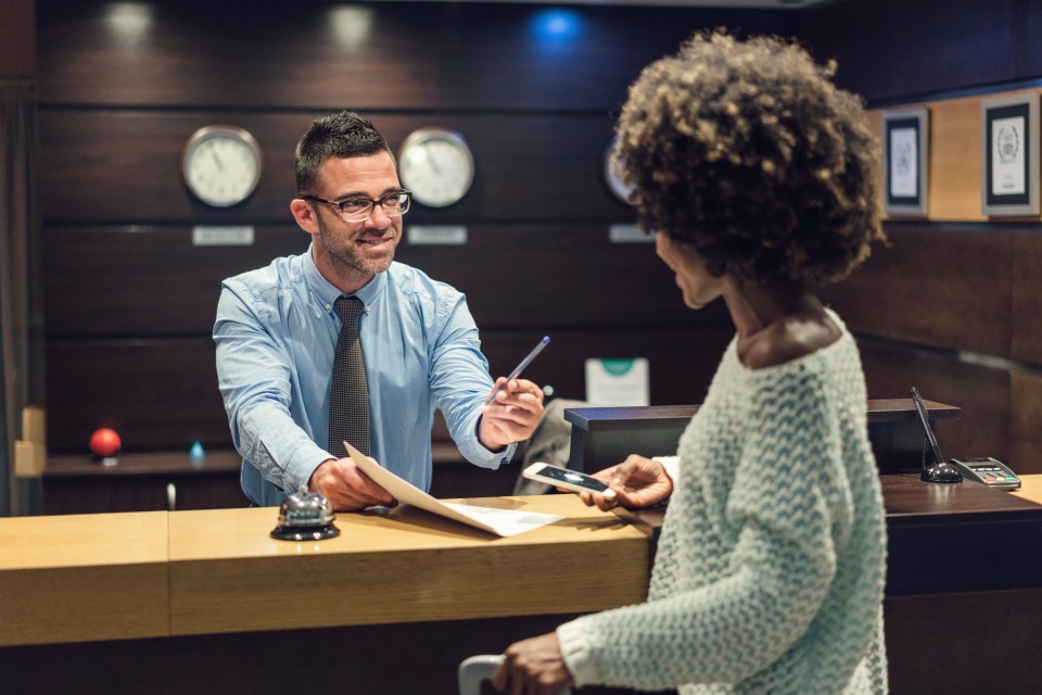 A hotel receptionist helps a guest check in.