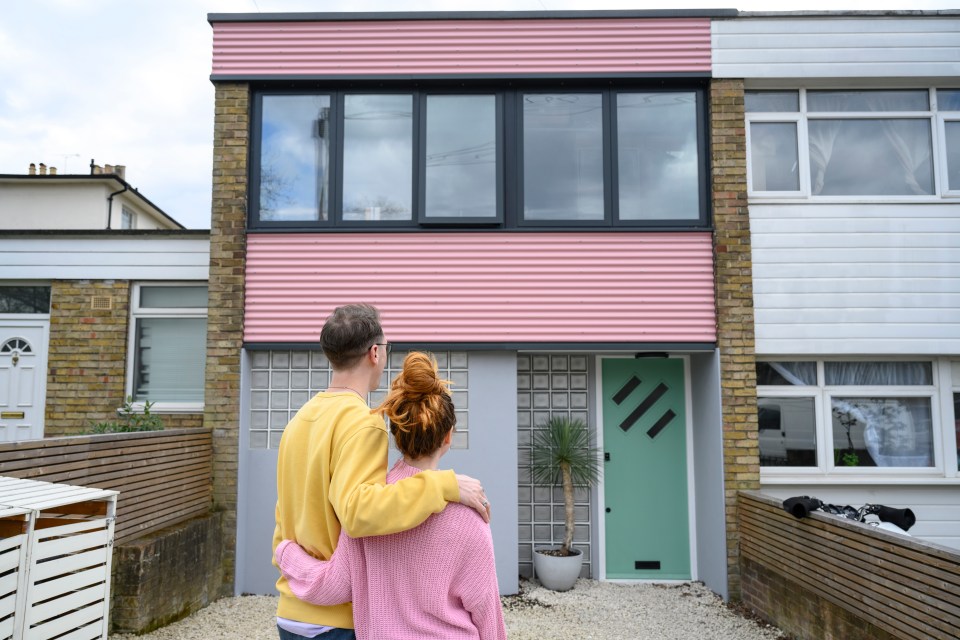 Couple admiring their new pastel-colored home.