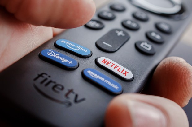 Amazon Fire TV remote with Netflix, Prime Video, Disney+, and Amazon Music buttons.