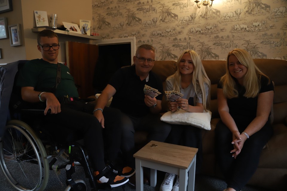 Rick, Lorraine, Ben, and Charlotte in their living room holding cash.