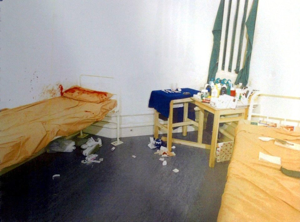 Crime scene photo of a prison cell with blood on one bed and a homemade knife.