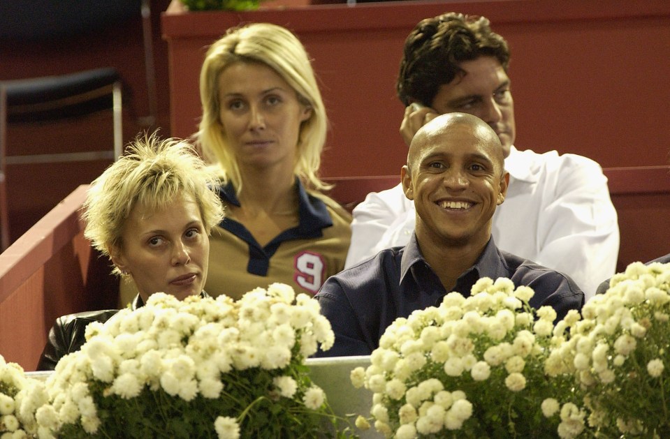 Roberto Carlos and his wife watching a tennis match.