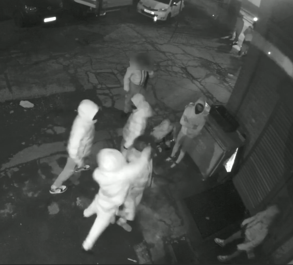 Security camera image of a group of people outside at night.