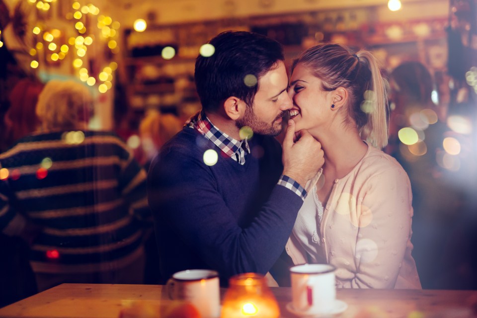 Romantic young couple kissing in a pub.