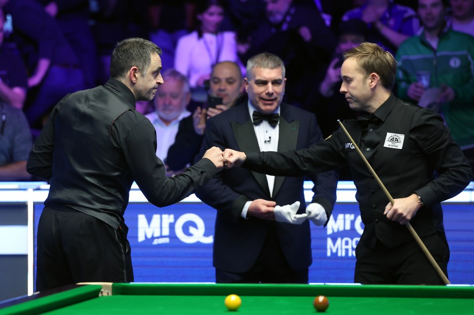 Ronnie O'Sullivan and Ali Carter shake hands after a snooker match.