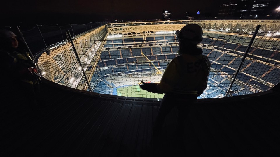 Construction manager overlooking Santiago Bernabéu Stadium at night.