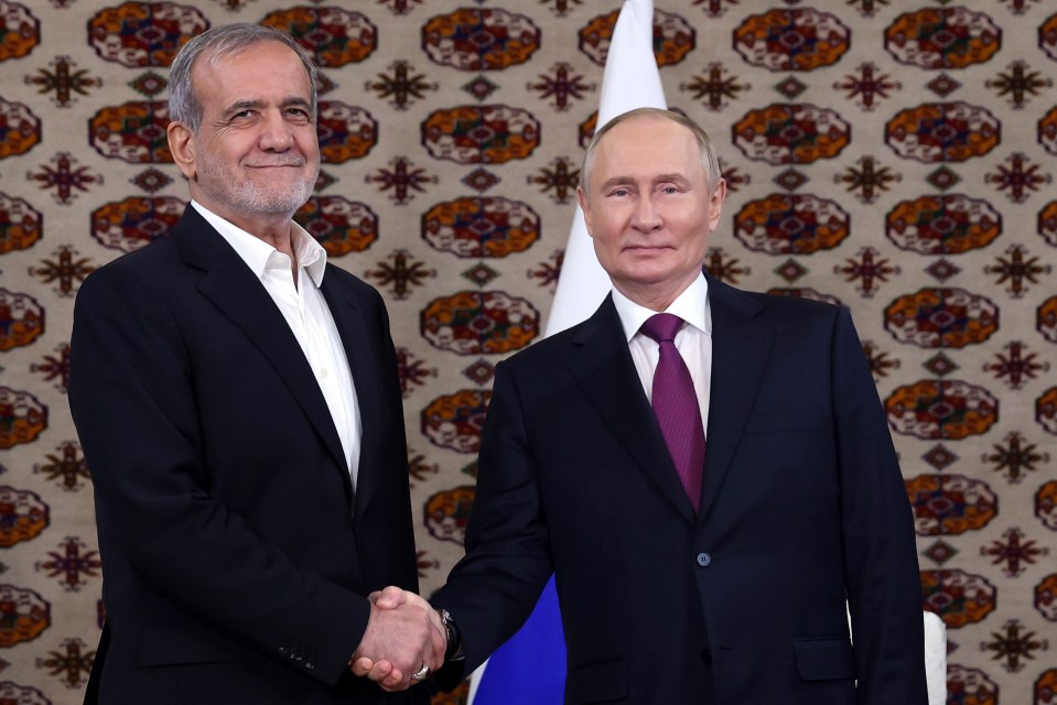 Vladimir Putin and Masoud Pezeshkian shaking hands.