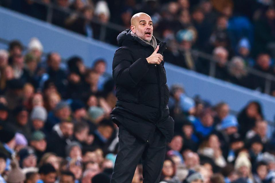 Pep Guardiola giving a thumbs up at a soccer game.