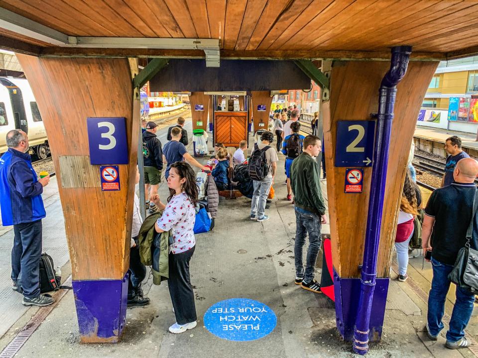 Passengers waiting on platforms 2 and 3 at a train station.