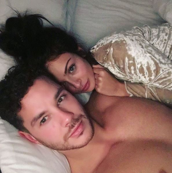 Scott Thomas and Kady McDermott cuddling in bed.