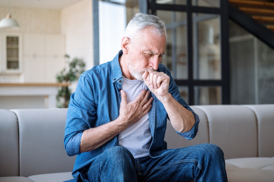 Senior man experiencing chest pain and coughing.