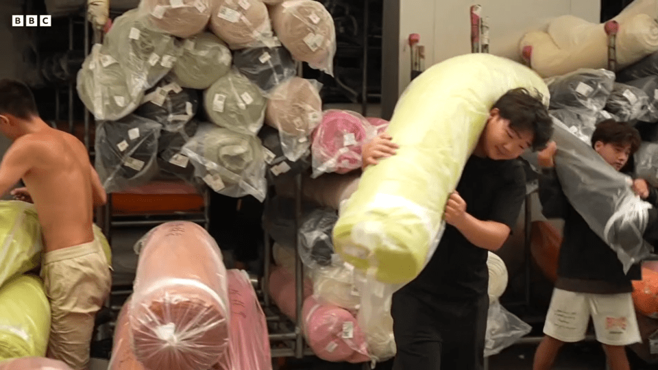 Workers carrying bolts of fabric in a Shein factory.