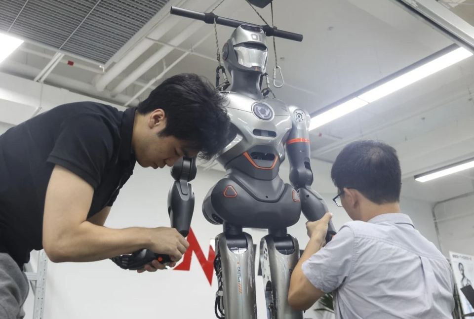 Two engineers working on a humanoid robot.