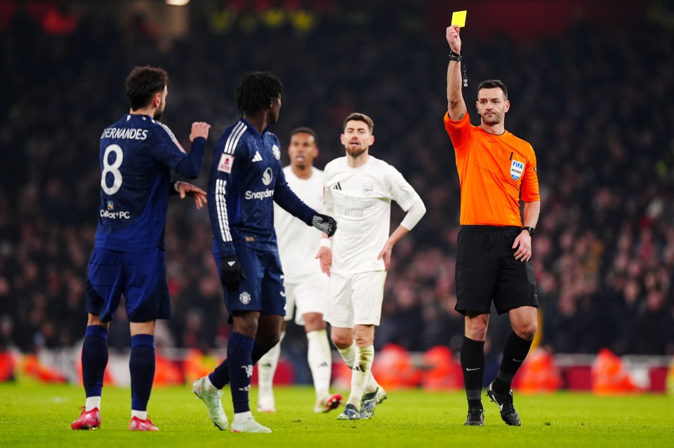 Referee showing a soccer player a yellow card.