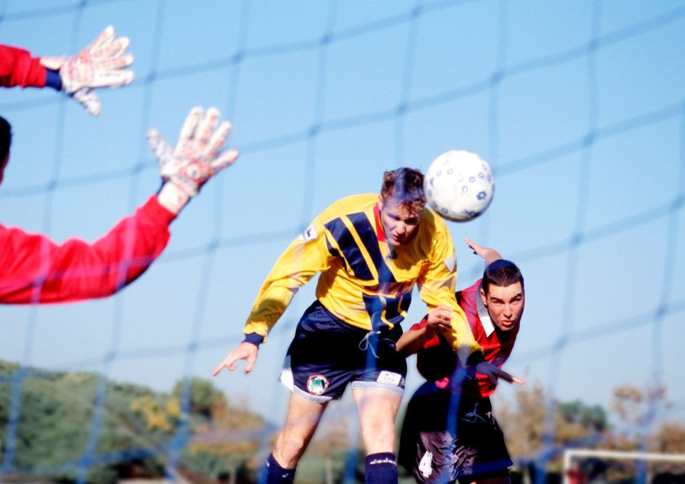 Soccer players vying for the ball near the goal.