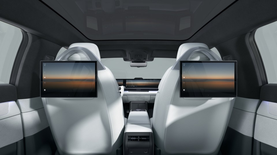 Rear view of the AFEELA electric vehicle's interior, showing two integrated screens on the back of the front seats.