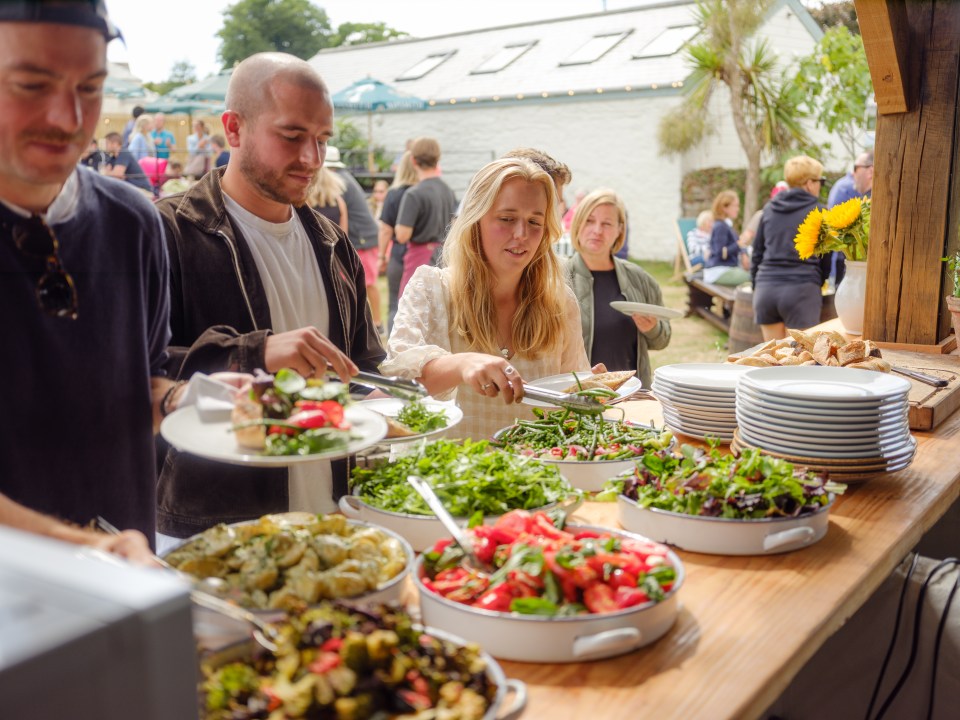 Guests serving themselves from a buffet of salads and other dishes at The Standard Inn.