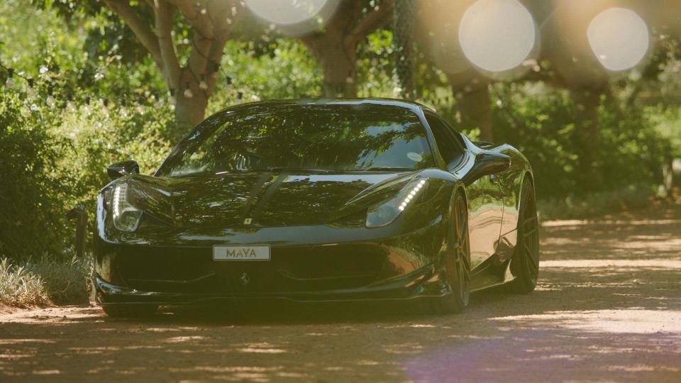 Black Ferrari with "MAYA" license plate.