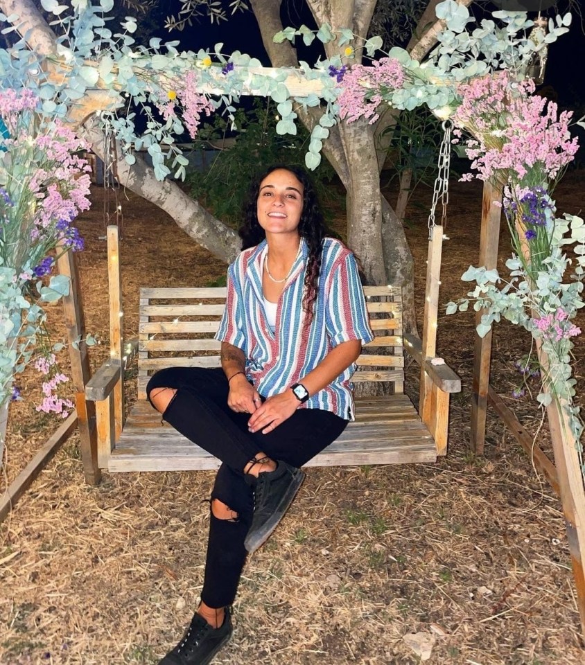 Woman sitting on a swing decorated with flowers.