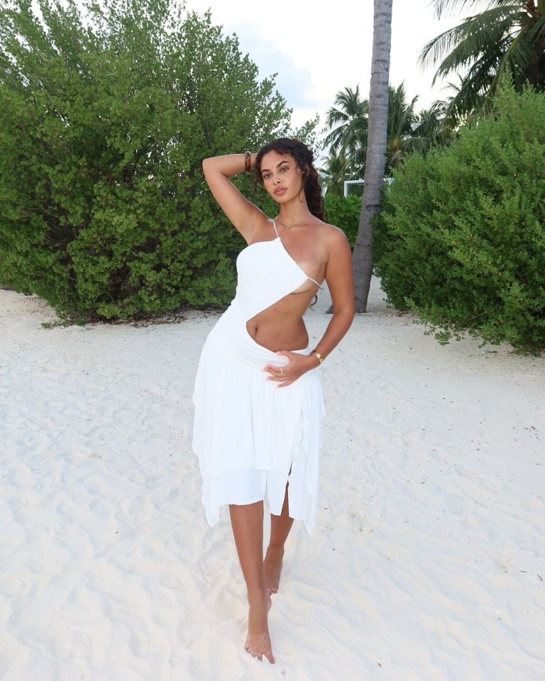 Woman in white dress on beach.