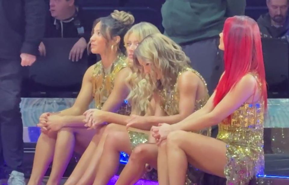 Four women in gold sequined dresses sitting together.