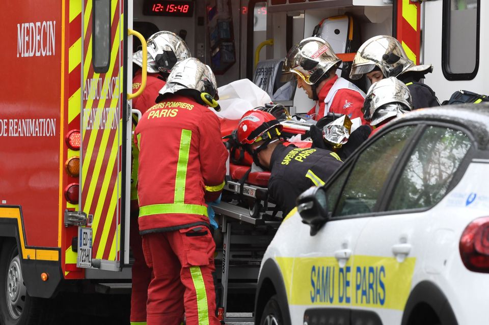 French firefighters load an injured person into a waiting ambulance near the former offices in 2020