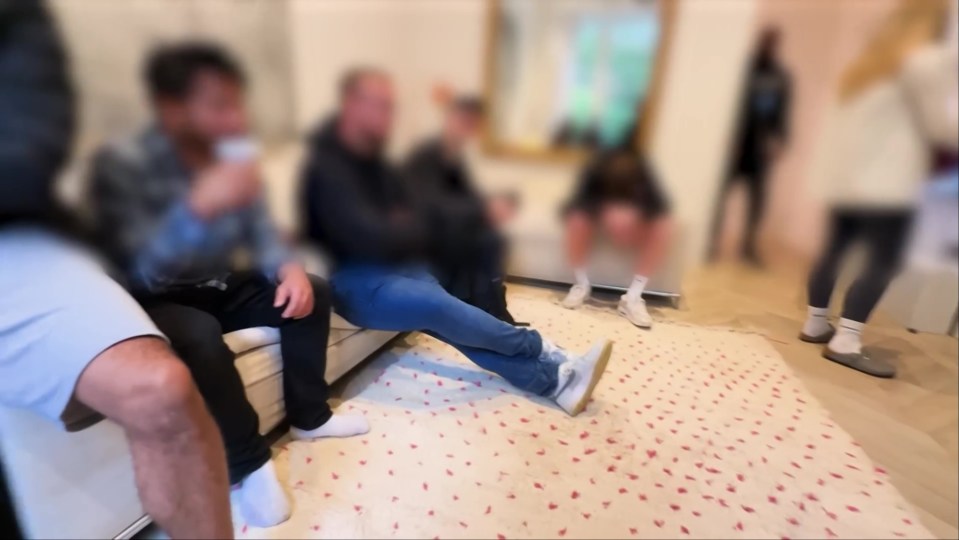 Blurred photo of several people sitting on a couch.