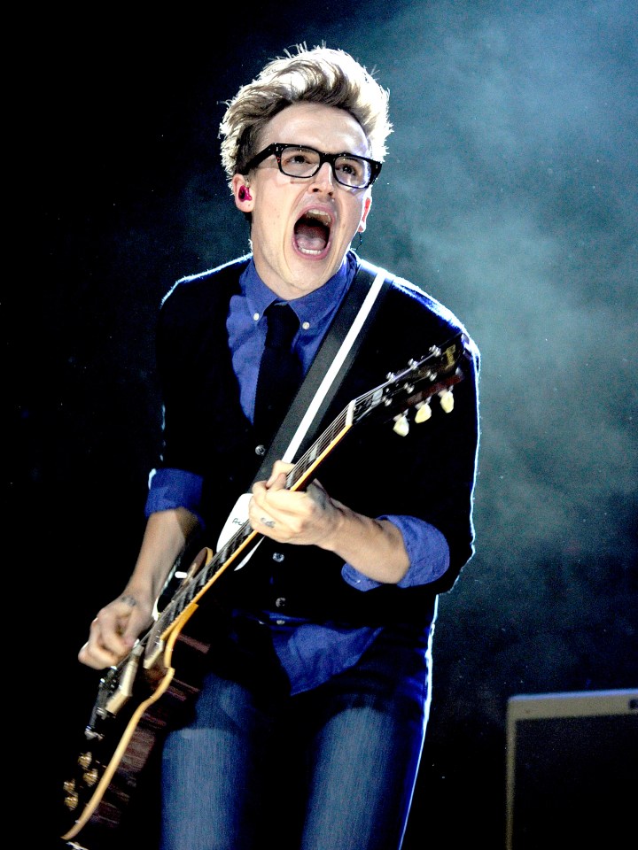 Tom Fletcher of McFly performing on stage with a guitar.