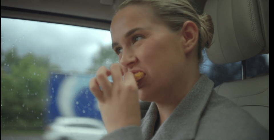 Woman eating in a car.