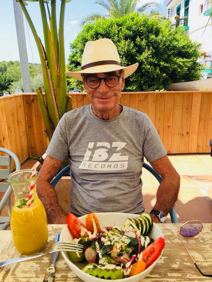 Tony Pike, founder of Pikes Hotel, outdoors at a table with a salad.