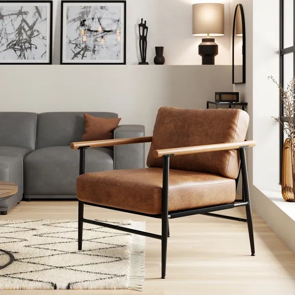 Brown leather armchair with wooden arms and black metal legs.