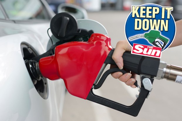 Hand holding a gas pump nozzle inserting fuel into a car.