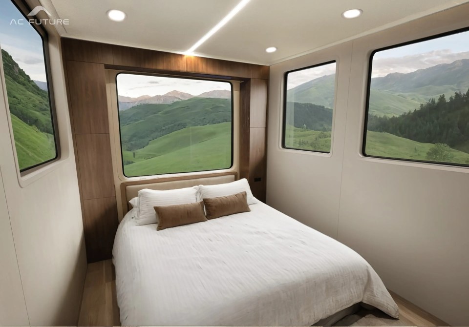 Bedroom in an expandable electric motorhome with a large window offering a scenic mountain view.