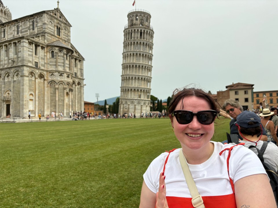 Woman in sunglasses in front of the Leaning Tower of Pisa.