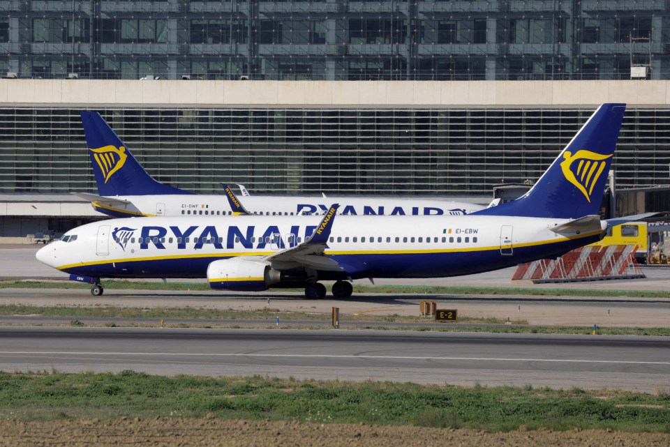 Two Ryanair Boeing 737-8AS passenger airplanes taxiing on a runway.