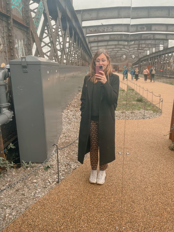 Woman taking a selfie under a bridge.