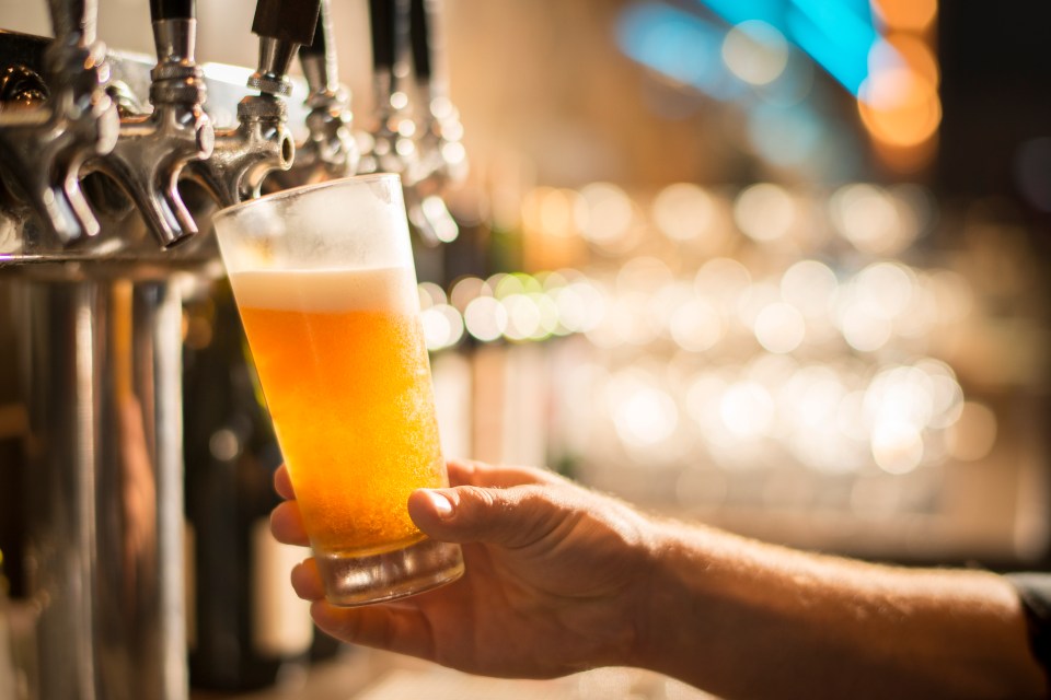 A bartender pouring beer into a glass.