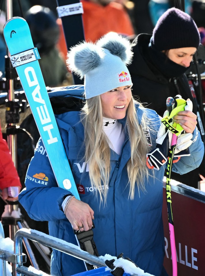 Lindsey Vonn holding skis after a downhill race.