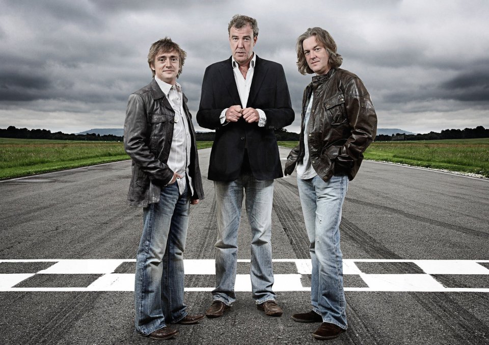 Richard Hammond, Jeremy Clarkson, and James May of Top Gear standing on a race track.