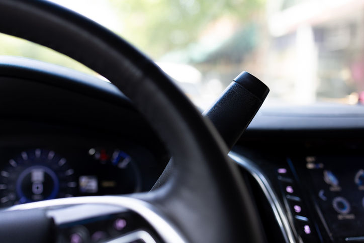 Vehicle interior with steering wheel and parking brake.