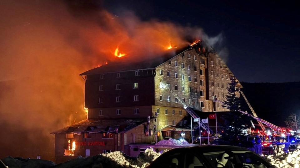 Firefighters battling a hotel fire at night.