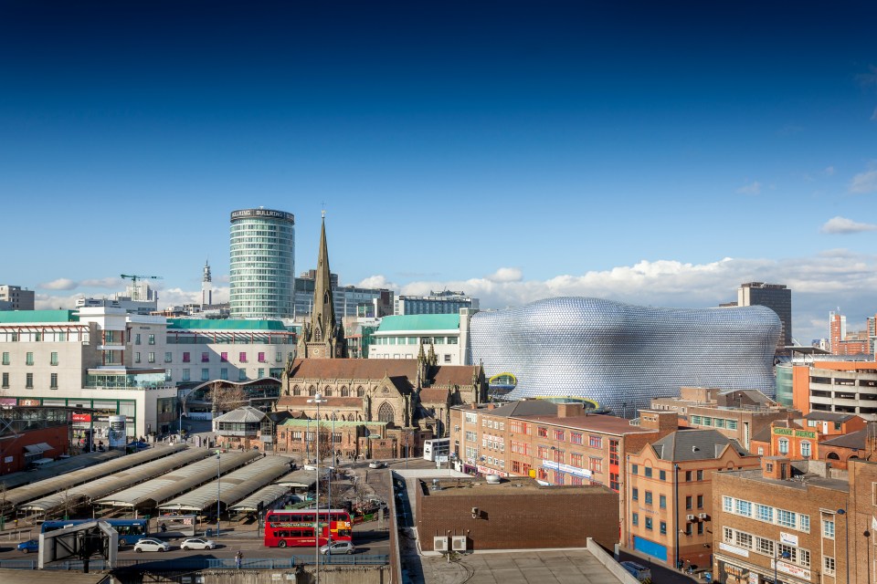 Birmingham skyline featuring St. Martin's Church, Bullring shopping centre, and outdoor market.