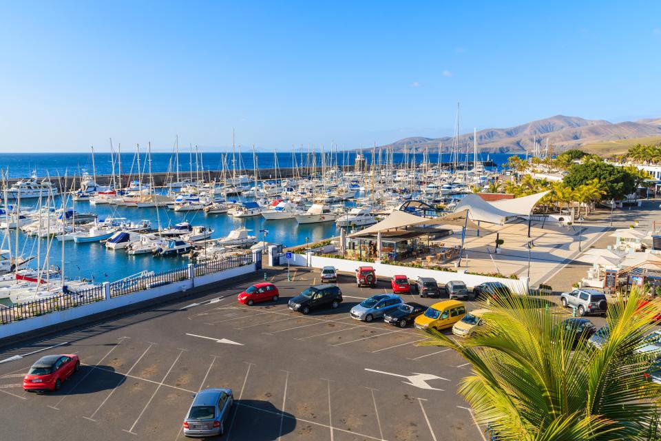 Puerto Calero marina in Lanzarote with many yachts and a parking lot.