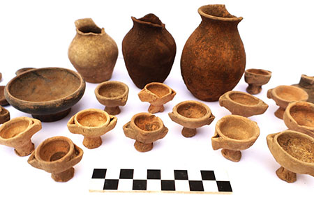 Collection of ancient pottery vessels and lamps.