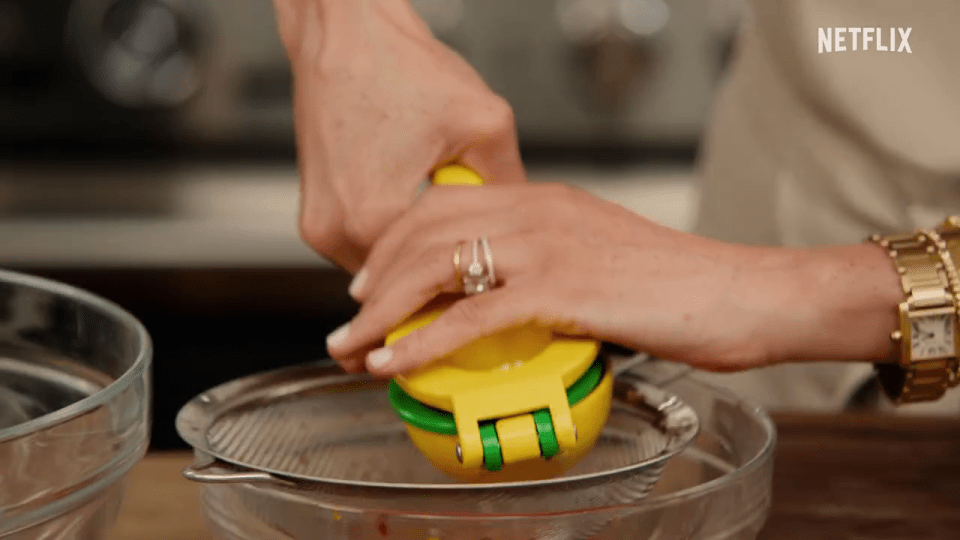 A person using a citrus juicer over a bowl.